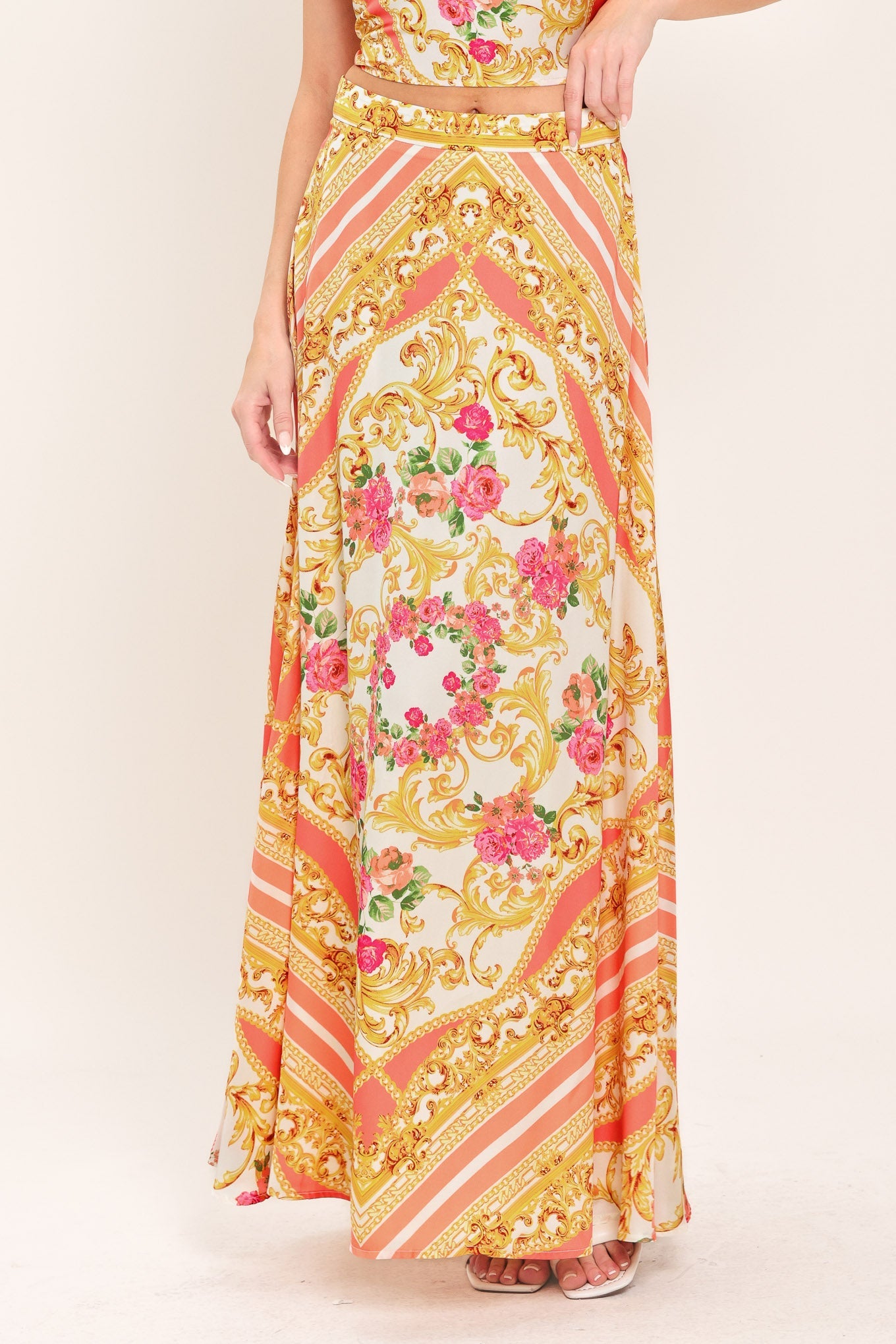 Long floral and gold patterned dress on a plain background