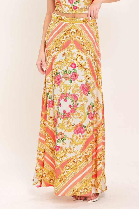 Long floral and gold patterned dress on a plain background